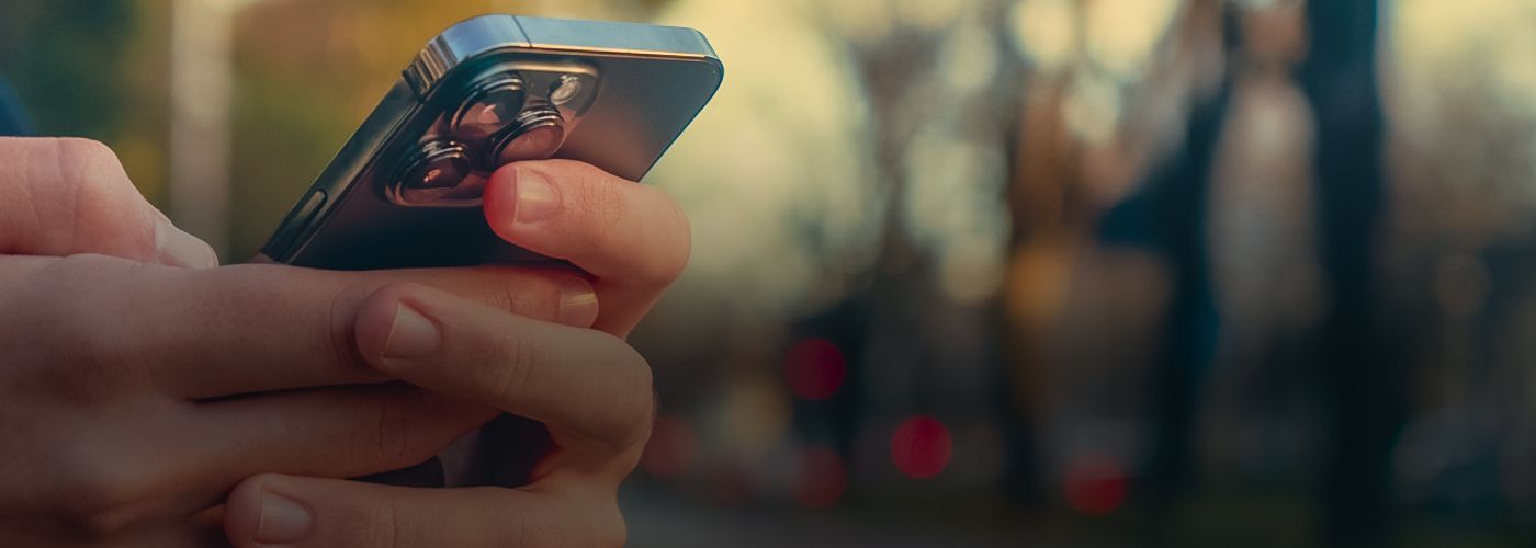 Zoom em uma mão de um homem mexendo no celular